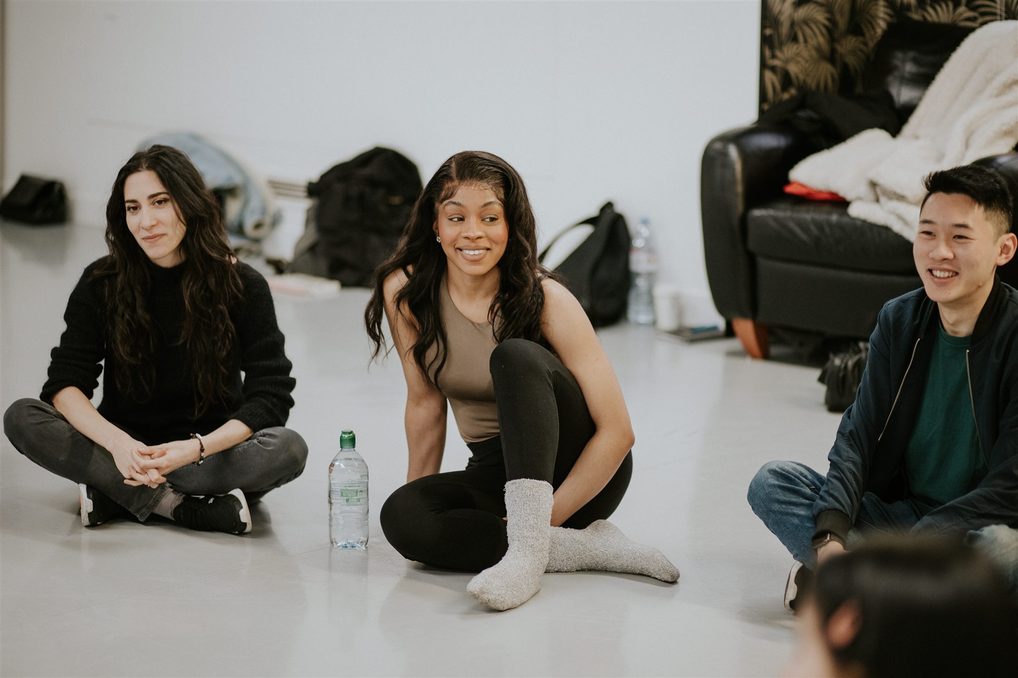 Performers sitting on the floor at an acting workshop