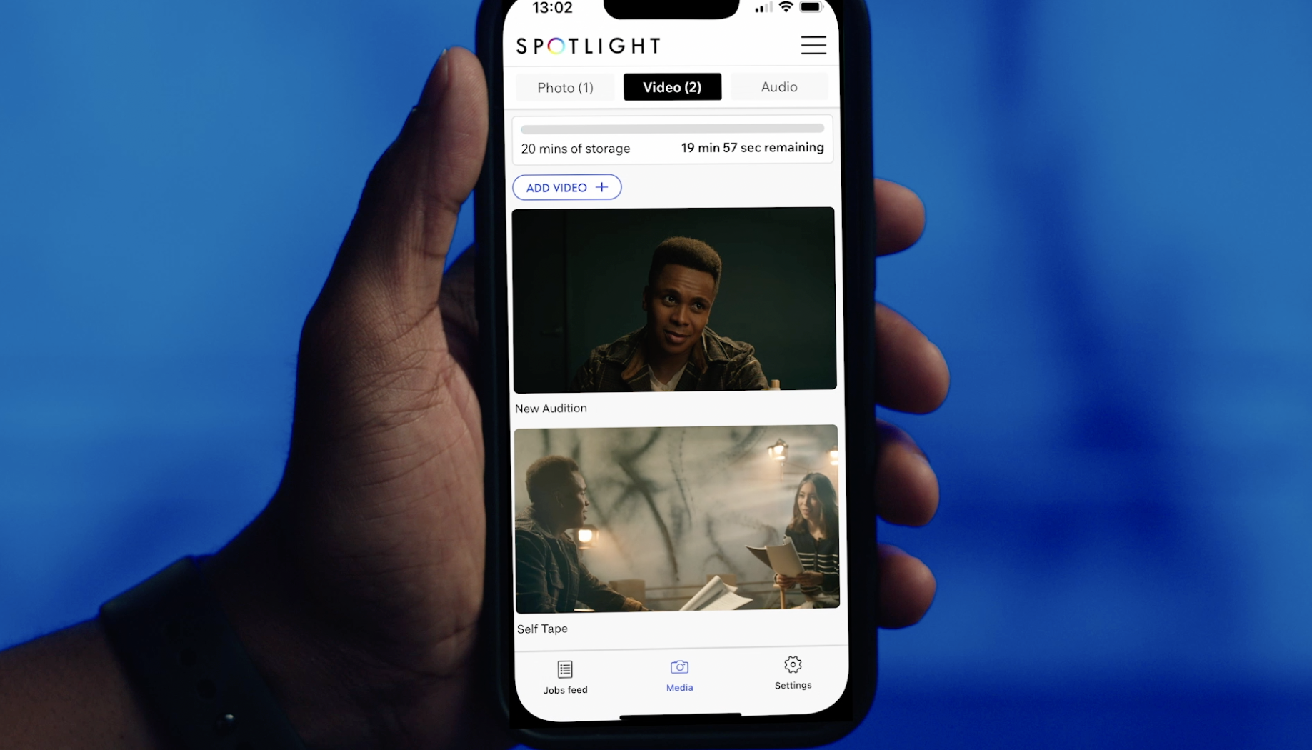 Someone holding their phone with the Spotlight website on the screen
